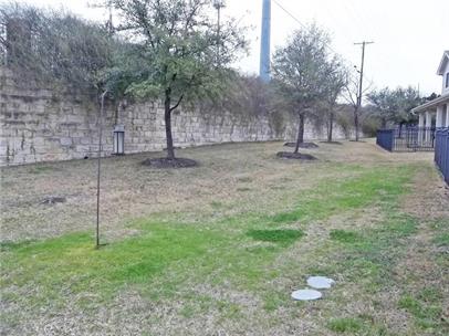 1900 Scofield Ridge Parkway, Unit 4701 Austin, TX 78727 - Photo 24 of 27 A deep backyard with a stone retaining wall provides ample space for outdoor activities and future landscaping.