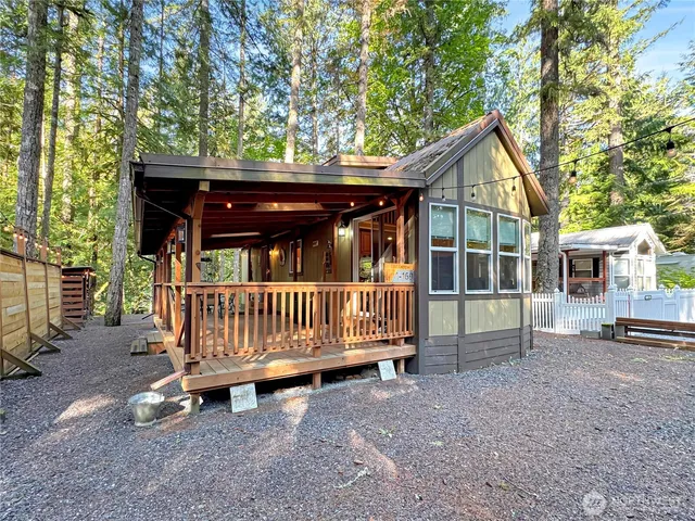 a view of backyard with a deck and a large tree