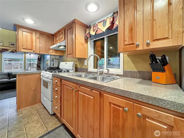 a kitchen with stainless steel appliances granite countertop a sink stove and cabinets