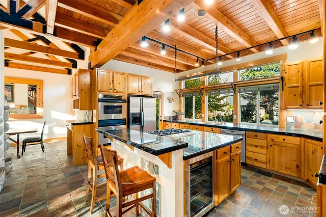 a kitchen with stainless steel appliances granite countertop a sink and wooden cabinets