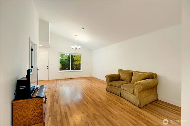 a view of a livingroom with kitchen island furniture and wooden floor