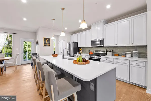 a living room with stainless steel appliances kitchen island furniture and a wooden floor