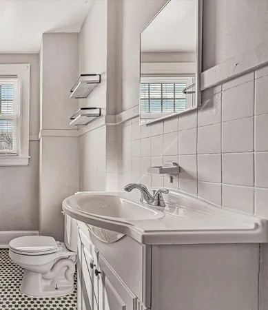 a bathroom with a sink a toilet and a mirror