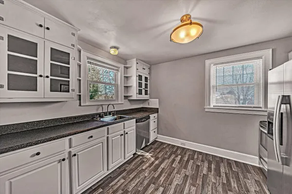 a kitchen with stainless steel appliances granite countertop a stove a sink and a microwave