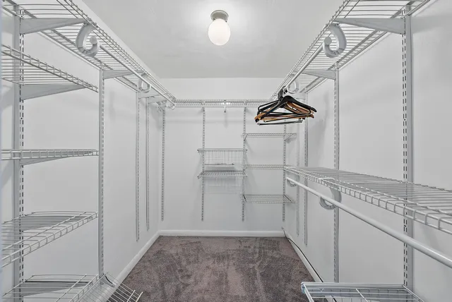 a view of a kitchen with white cabinets and wooden floor