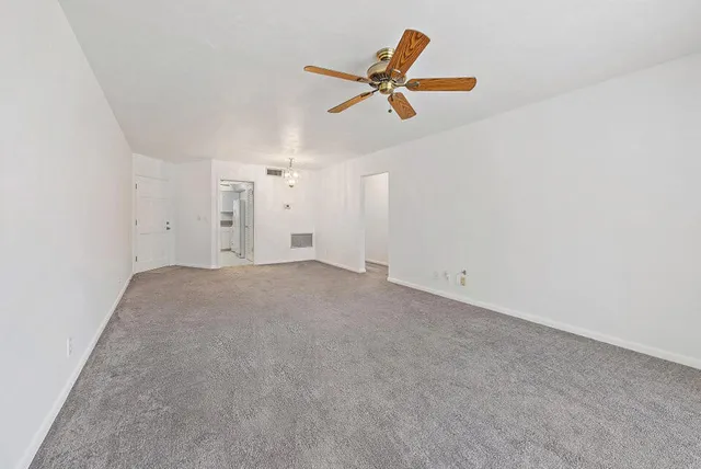 a view of a livingroom with a ceiling fan and wooden floor