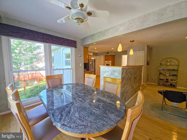 a large kitchen with stainless steel appliances granite countertop a stove a sink dishwasher and a view of living room