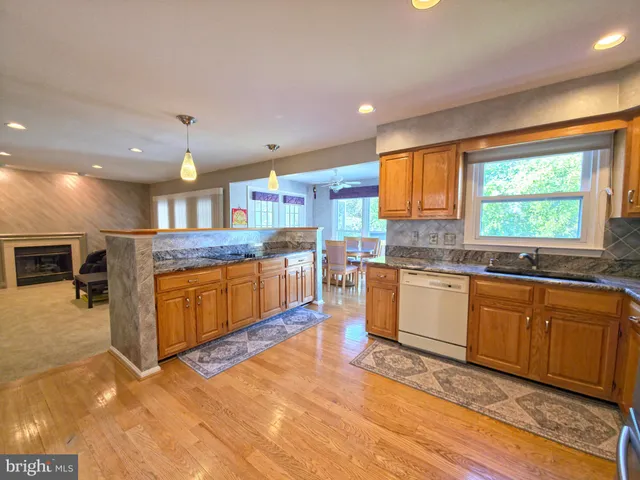a kitchen with stainless steel appliances granite countertop a refrigerator a stove and a sink