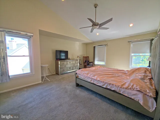 a spacious bedroom with a bed and a chandelier