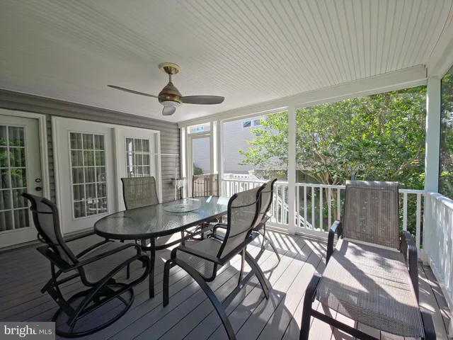 a balcony with wooden floor and trees in the back