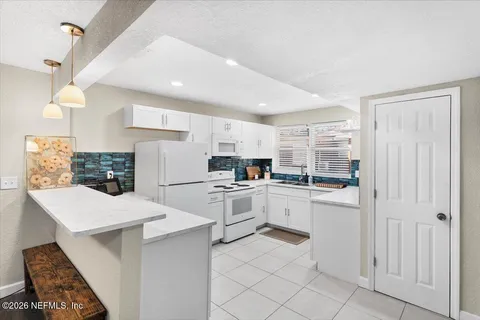 a kitchen with white cabinets and white appliances