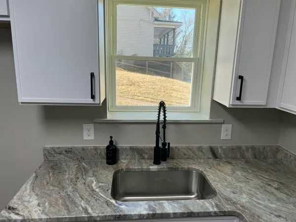 a kitchen with sink a window and cabinets