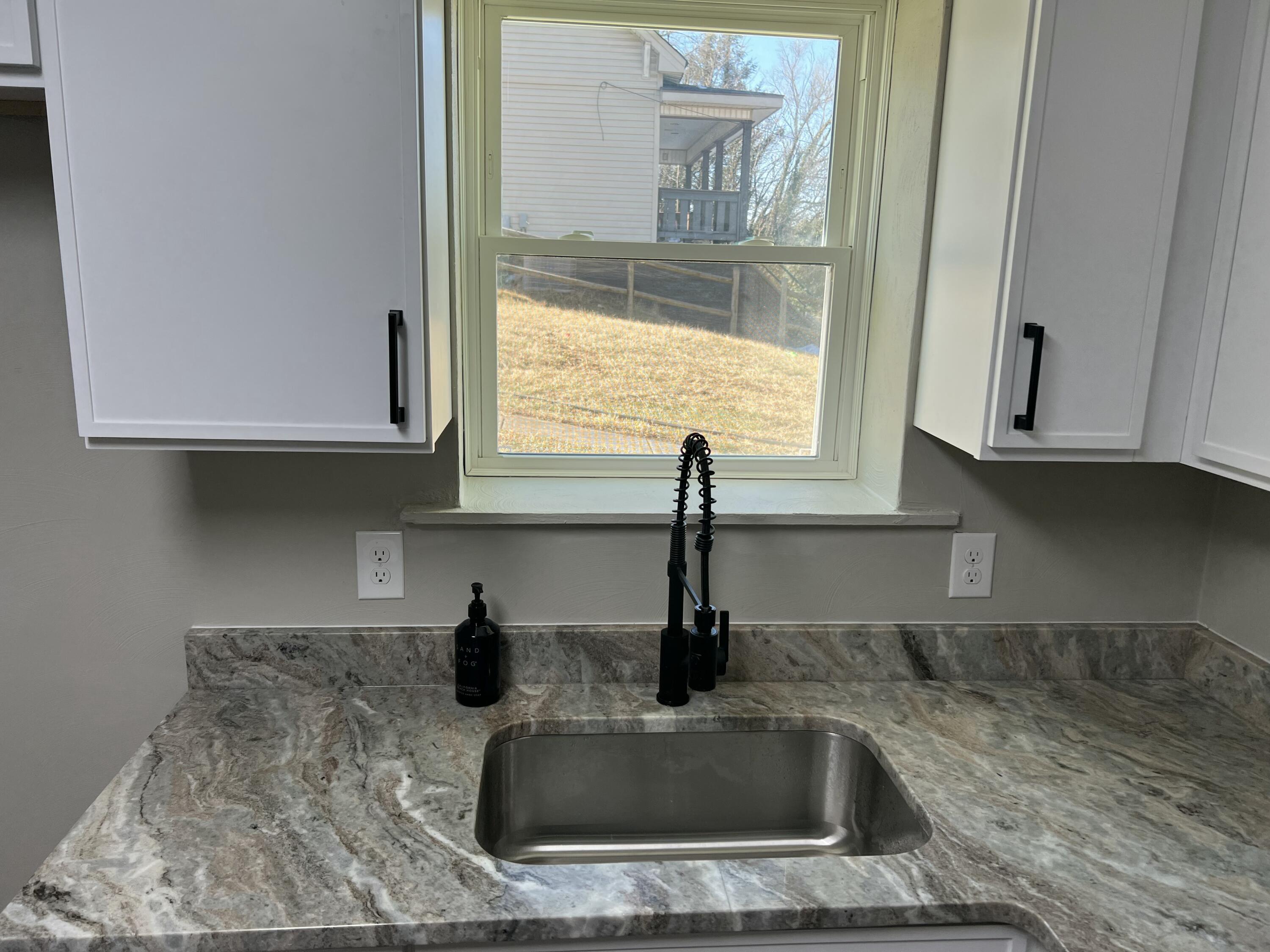 602 Rutherford Avenue Northwest Roanoke, VA 24016 - Photo 7 of 15 a kitchen with sink a window and cabinets