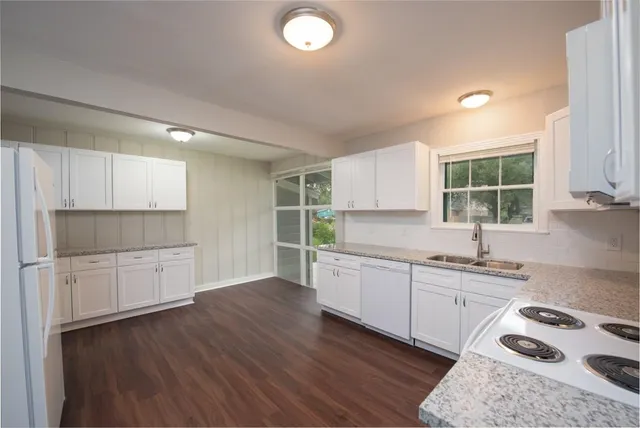 a kitchen with a sink a window and cabinets