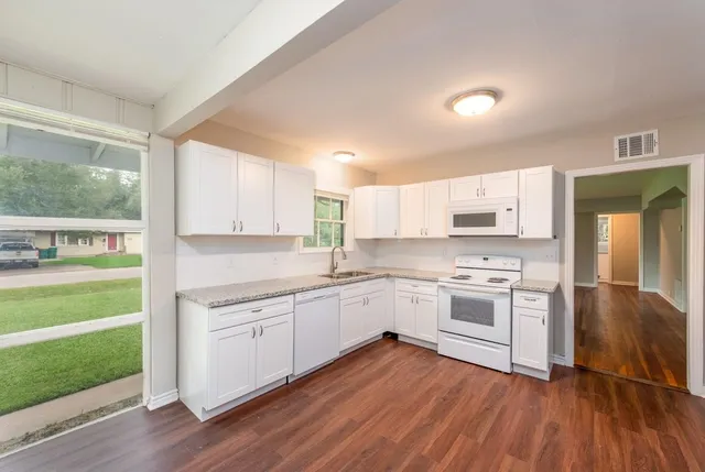 a kitchen with a sink a stove and cabinets