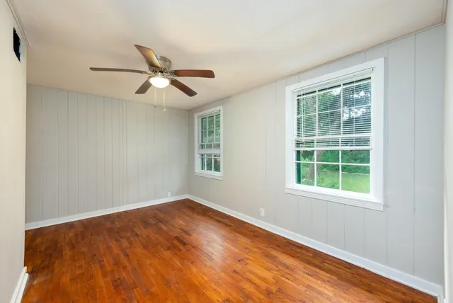 an empty room with a window and a fan