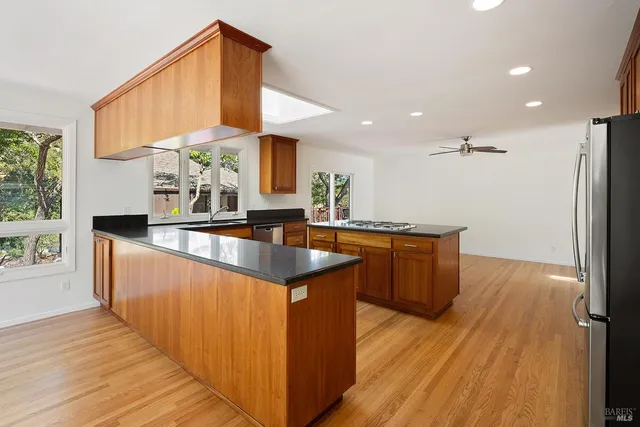 a kitchen with stainless steel appliances granite countertop a sink stove and wooden floor