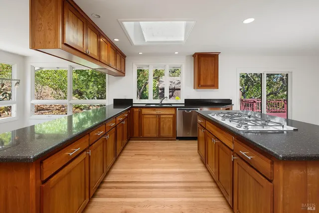 a kitchen with stainless steel appliances granite countertop sink stove and refrigerator