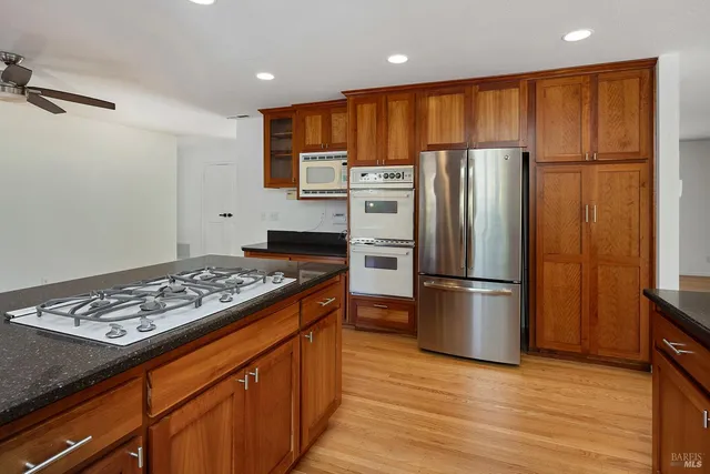 a kitchen with stainless steel appliances granite countertop a refrigerator stove top oven and sink