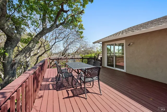 a view of a patio with a table and chairs next to a yard