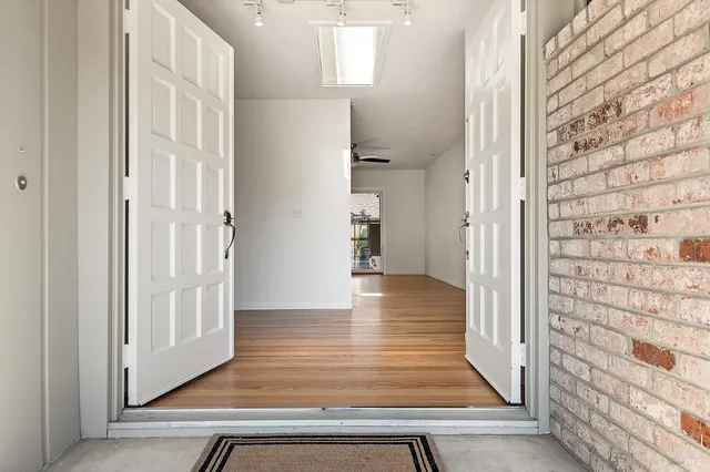 a view of a hallway with wooden floor and staircase