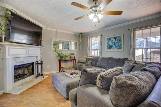 a living room with furniture a flat screen tv and a fireplace
