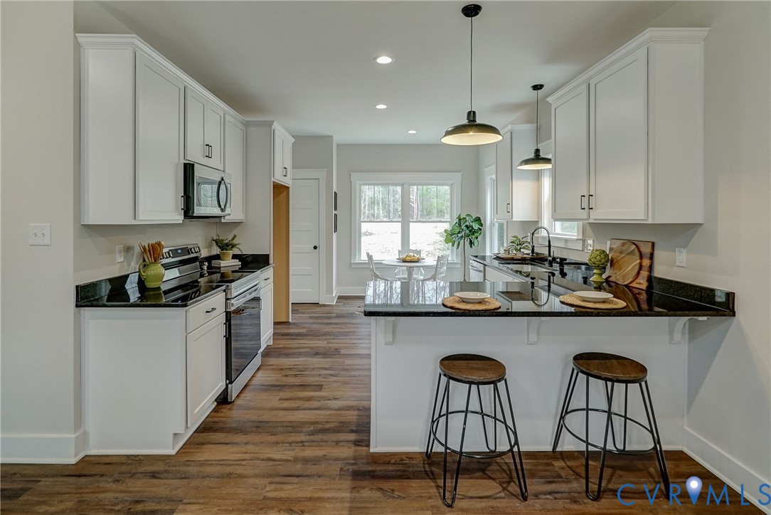 1343 Stokes Station Road Goochland, VA 23063 - Photo 14 of 35 a kitchen with stainless steel appliances granite countertop a stove top oven a refrigerator a sink and chairs