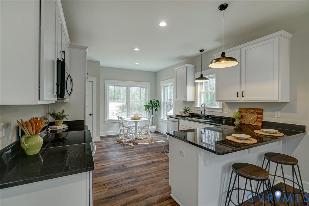 1343 Stokes Station Road Goochland, VA 23063 - Photo 15 of 35 a kitchen with a dining table chairs sink and white cabinets