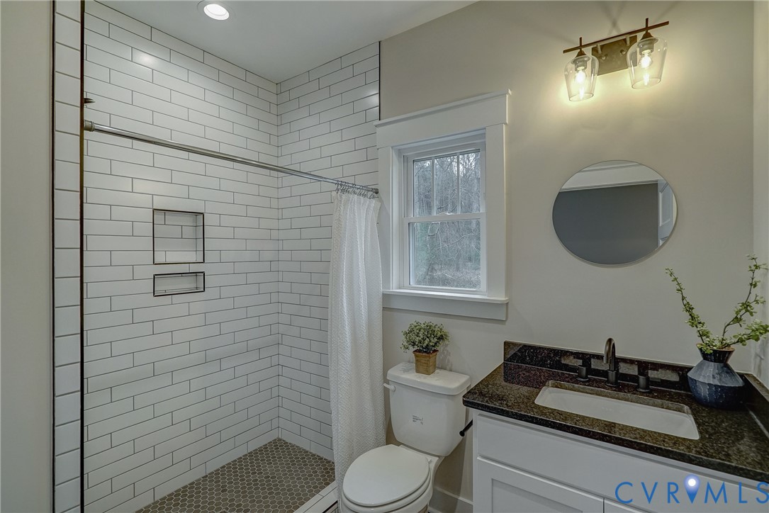 1343 Stokes Station Road Goochland, VA 23063 - Photo 34 of 35 a bathroom with a granite countertop toilet sink and mirror