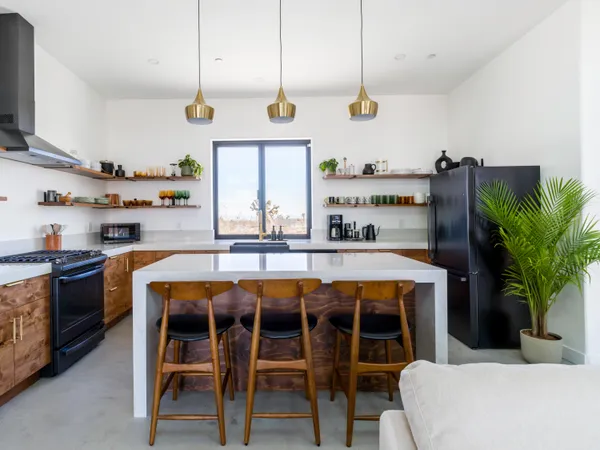 a living room with furniture a rug and kitchen view