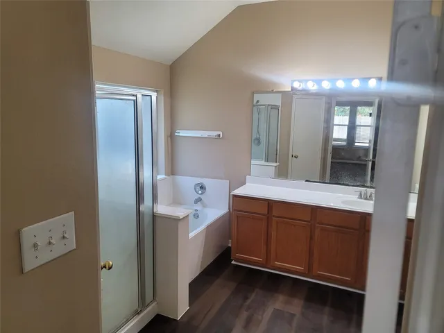 a spacious bathroom with a tub sink and mirror