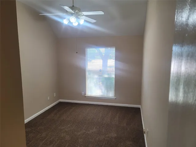 en empty room with windows and chandelier fan