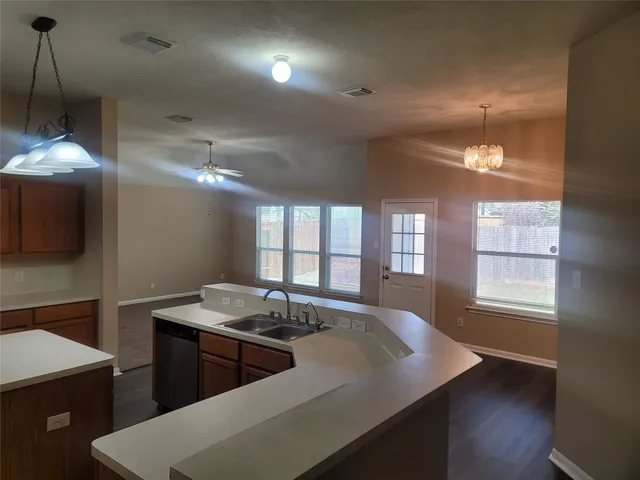 a kitchen with sink and view of living room