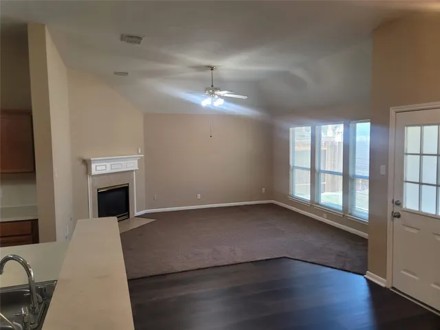 a view of a livingroom with wooden floor fireplace and windows