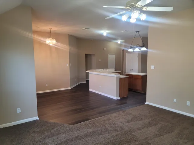 a view of a kitchen with a sink and chandelier fan