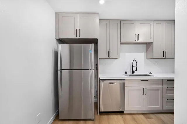 a kitchen with stainless steel appliances a refrigerator and cabinets