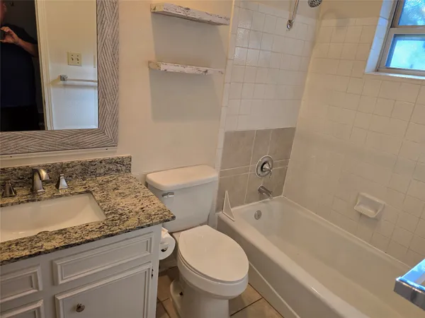 a bathroom with a granite countertop toilet a sink and bathtub