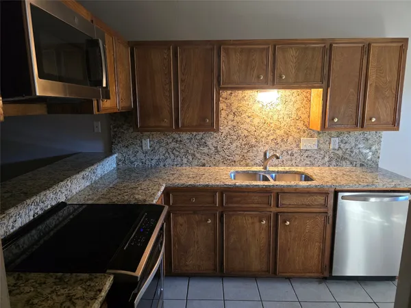 a kitchen with a sink stove and microwave