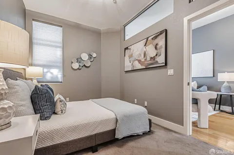 a bedroom with a bed and a painting on the wall