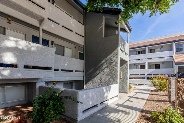 a front view of a building with a garden and entryway