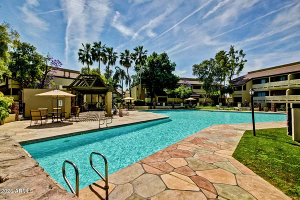 a view of a house with a big yard potted plants and a large tree