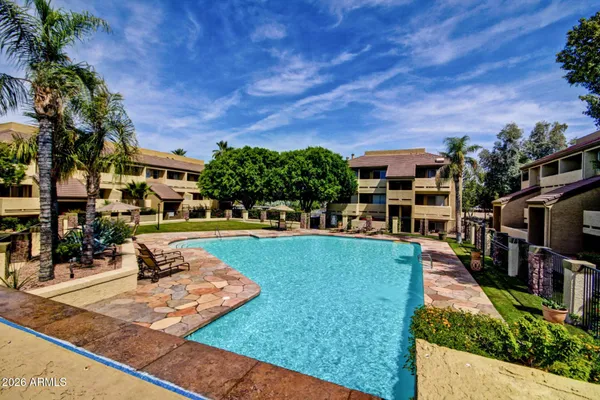 a front view of a building with a garden and plants