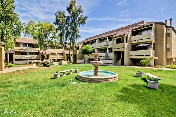 a front view of a house with garden and sitting area