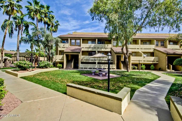 a view of a house with potted plants and a bench