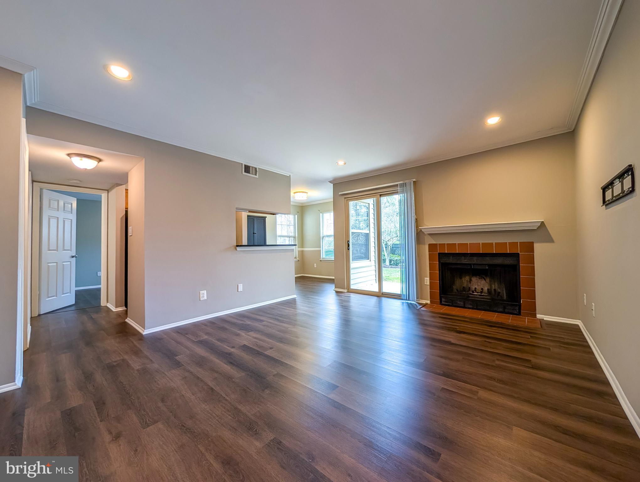 1708 Abercromby Court, Unit 1708B Reston, VA 20190 - Photo 2 of 26 a view of an empty room with wooden floor fireplace and a window