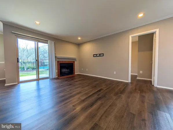 a view of empty room with wooden floor and fireplace