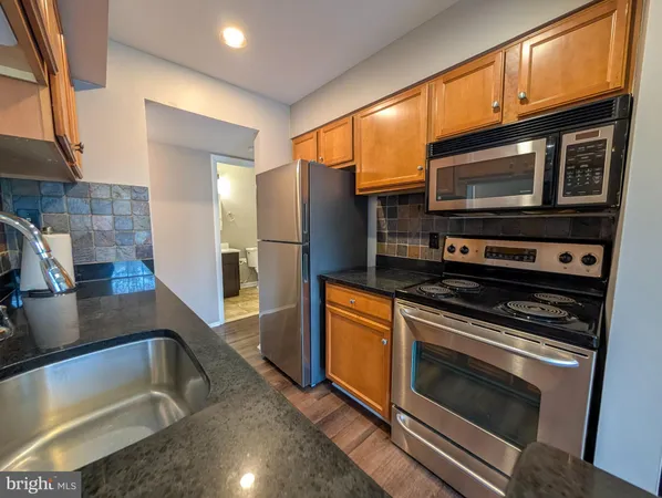 a kitchen with stainless steel appliances a stove a microwave and a sink