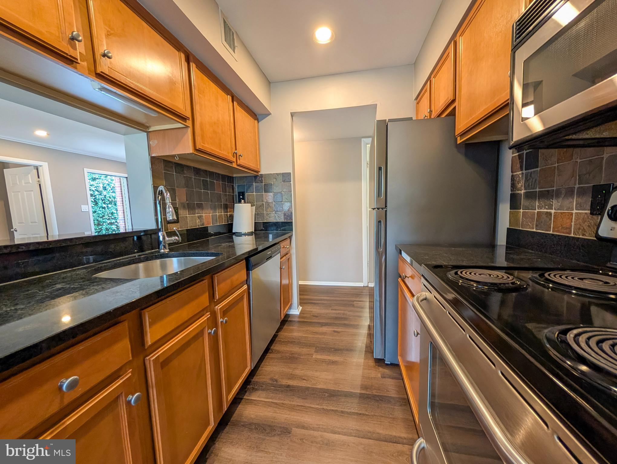 1708 Abercromby Court, Unit 1708B Reston, VA 20190 - Photo 7 of 26 a kitchen with stainless steel appliances granite countertop a stove and a refrigerator