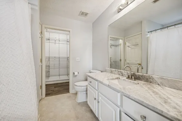 a bathroom with a granite countertop sink toilet and shower