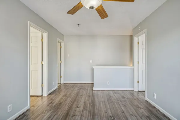 a view of empty room with wooden floor